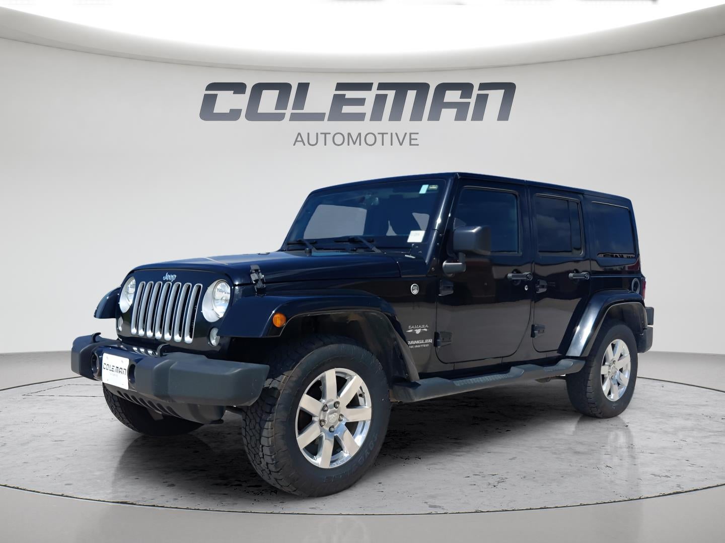 2016 Jeep Wrangler Unlimited Sahara in Black — front three-quarter view